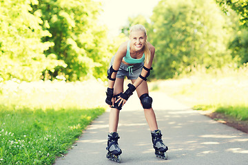 Image showing happy young woman in rollerskates riding outdoors