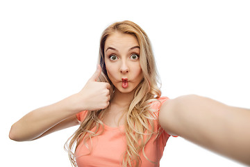 Image showing young woman taking selfie and showing thumbs up