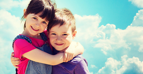 Image showing two happy kids hugging over blue sky and clouds