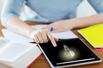 Image showing close up of student with light bulb on tablet pc