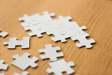 Image showing close up of puzzle pieces on wooden surface