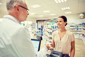 Image showing woman giving money to pharmacist at drugstore