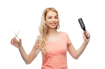 Image showing young woman with scissors and hairbrush