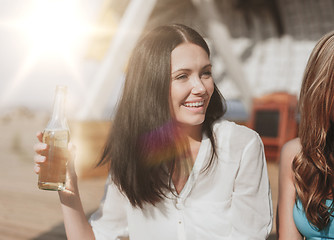 Image showing girl with drink and friends on the beach