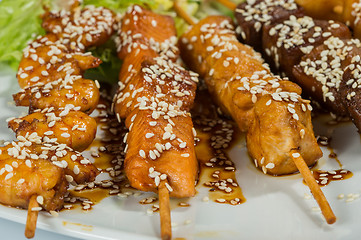 Image showing Grilled juicy skewered shashlik on a plate, sesame