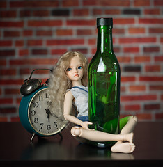 Image showing doll with a bottle. the concept of alcoholism