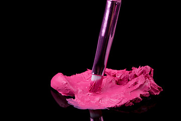 Image showing lipstick with a brush make-up on black 