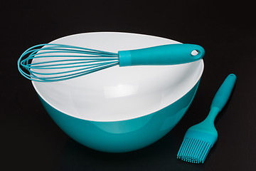 Image showing Green silicone pastry brush and soup plate isolated on black