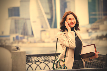 Image showing smiling middle-aged woman using a smartphone