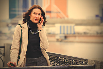 Image showing middle-aged woman talking on the phone and smiling