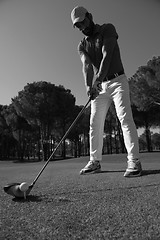 Image showing golf player placing ball on tee