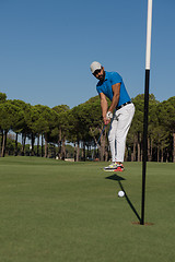 Image showing golf player hitting shot at sunny day