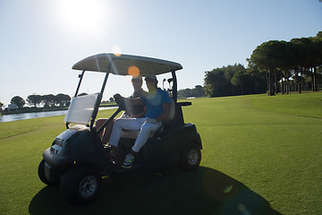 Image showing golf players driving cart at course