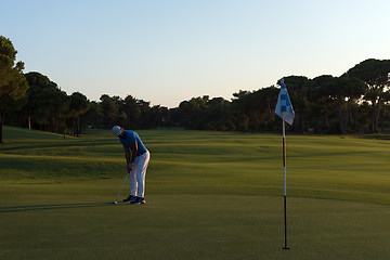 Image showing golfer hitting ball to hole