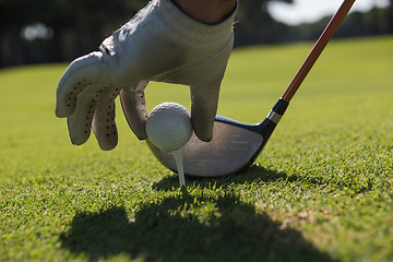 Image showing golf player placing ball on tee