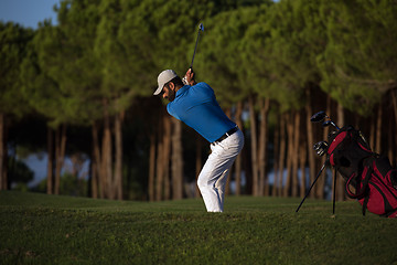 Image showing golfer hitting a sand bunker shot on sunset