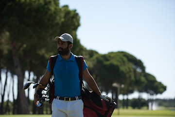 Image showing golf player walking and carrying bag