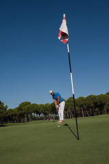 Image showing golf player hitting shot at sunny day