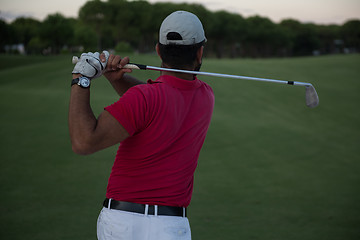 Image showing golfer hitting a sand bunker shot on sunset