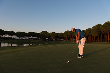 Image showing golfer  hitting shot at golf course