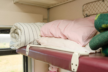 Image showing The top shelf in the second-class compartment of the train wagon with bedding