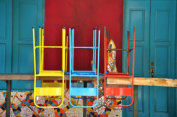 Image showing Colorful chairs on a wooden table