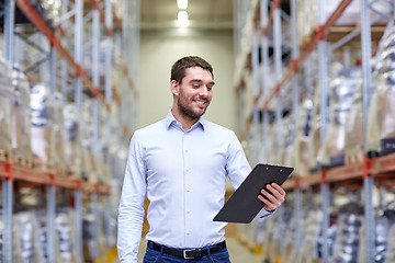 Image showing happy businessman with clipboard at warehouse