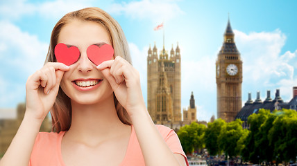 Image showing happy young woman with red heart shapes on eyes