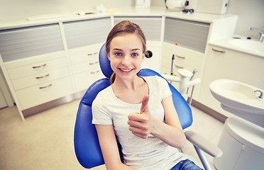 Image showing happy patient girl showing thumbs up at clinic