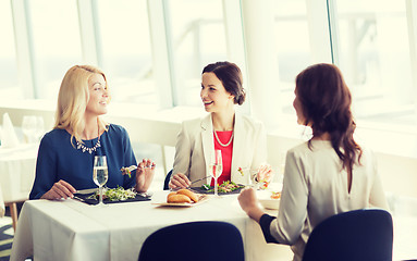 Image showing happy women eating and talking at restaurant