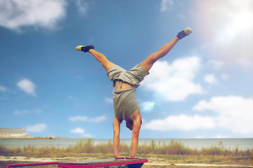 Image showing young man exercising on bench outdoors