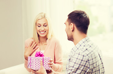 Image showing happy man giving woman gift box at home