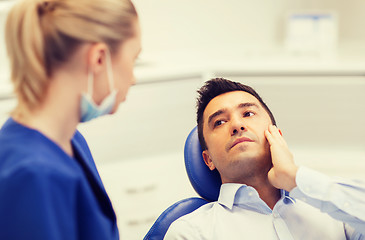 Image showing female dentist and male patient with toothache