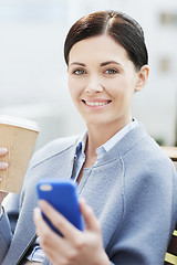 Image showing smiling woman with coffee and smartphone