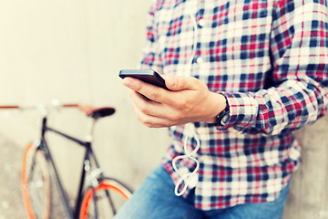 Image showing close up of hipster man with smartphone and bike