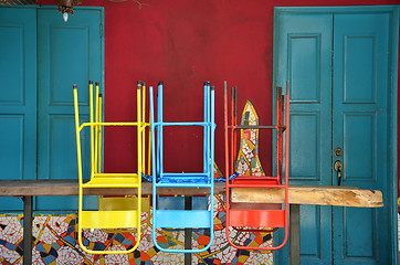 Image showing Colorful chairs on a wooden table