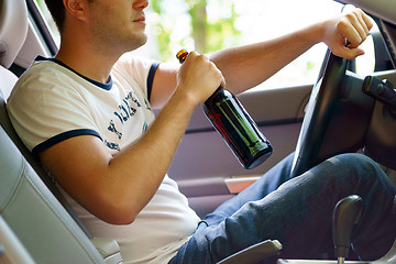 Image showing Man drinking beer while driving the car.