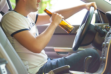 Image showing Man drinking beer while driving the car.