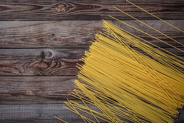 Image showing Yellow long spaghetti on black background. Raw spaghetti.