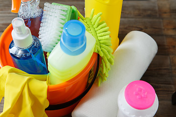 Image showing Plastic bucket with cleaning supplies on wood background