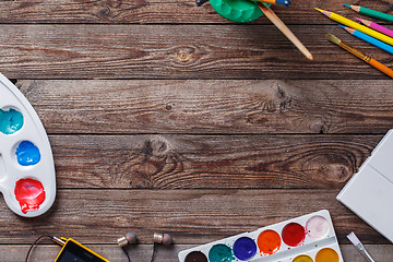 Image showing Paper, watercolors, paint brush and some art stuff on wooden   table