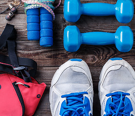 Image showing Shoes and sports equipment on wooden floor, top view