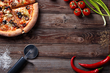 Image showing Tasty pizza with ingridients on a wooden board.