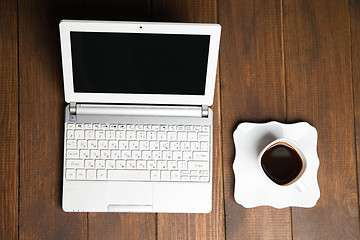 Image showing Delicious cup of black coffee near laptop