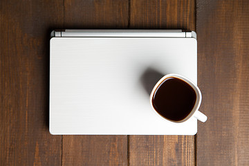 Image showing Cup of coffee on laptop