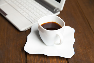 Image showing Close-up of black coffee near laptop keyboard