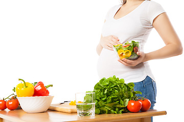 Image showing Close-up of pregnant woman holding bowl with fresh vegetables