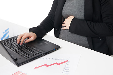 Image showing Businesswoman waiting for baby while working on laptop