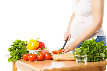 Image showing Close-up of pregnant woman cutting tomato