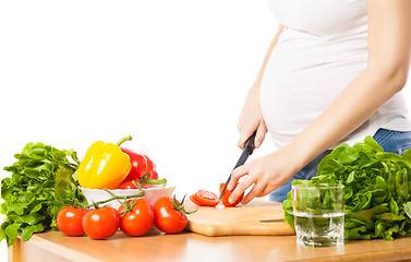 Image showing Close-up of pregnant woman cutting tomato